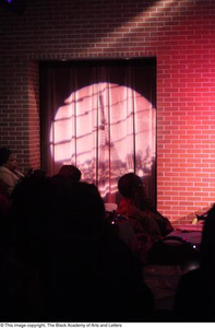 Audience and spotlight on curtain doorway