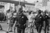 Police officers and marchers at a United Klans of America march and rally in Mobile, Alabama.