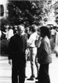 John P. Raynor, S.J., speaks with a student on the sidewalk, circa 1980