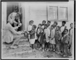 Typical colored school near Shaw, Mississippi. It is held in a church. The teacher is distributing fruit sent to the Red Cross from Lake Wales, Florida