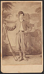 [Unidentified soldier in Zouave Union uniform and stocking cap with Model 1817 Common Rifle converted to percussion in front of painted backdrop showing cannon, drum, flag, and sailing ship]