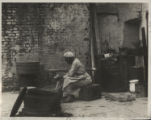 African-American tenement. Courtyard, woman washing.