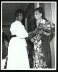 Unidentified woman presenting flowers to another woman, COGIC, Chicago