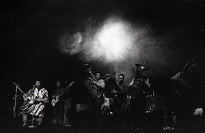 Taj Mahal in concert at Northfield, Mass.: Taj Mahal (guitar) and horn section with light show behind