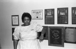 Bonaventure Hotel Intern Libby Clark posing next to awards, Los Angeles, 1985