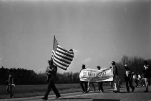 Man carrying an American flag during the 20th anniversary reenactment of the Selma to Montgomery March.