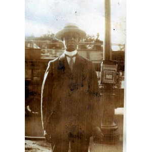 An African American man standing outside next to a letter box