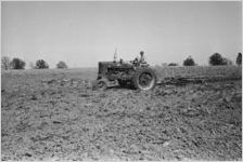 African American man on tractor working [Slide Farm-13]