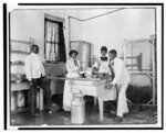 [Students operating a small cotton gin at the Tuskegee Normal and Industrial Institute]