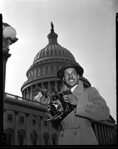 Robert Scurlock in front of Capitol with Speed Graphic camera : acetate film photonegative]