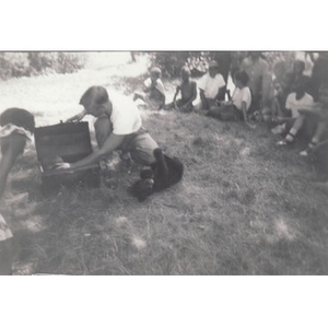 Black bear cub plays with instructor