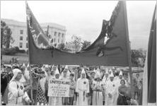 Two Klansmen holding a burning banner at a Ku Klux Klan rally in Montgomery, Alabama.