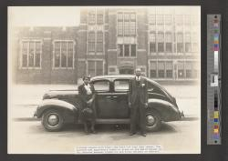 African American couple posed in front of Ford sedan