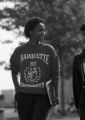 A student wearing a vintage Marquette sweatshirt walks around campus, 1989