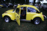 Man sitting in yellow Volkswagen