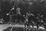 Joe Thomas attempts to retrieve a rebound in a game against LSU while teammates Gary Brell and Ric Cobb look on, 1970