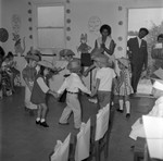 Boys and girls wearing cowboy hats dance in a circle