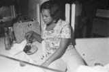 Clara Blackwell eating while seated behind a counter at the Laicos Club in Montgomery, Alabama.