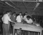 Professors discussing drawings of leaves with students in a classroom at Tuskegee Institute in Tuskegee, Alabama.