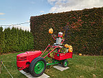 Stewart Melrose, an interior designer and historical preservationist in Fenton, Michigan, picked up a love of ornamental gardening from his father and mother, Howard and Sonya Melrose. Together, they created and regularly expand a remarkable garden beside the parents' home. It includes tropical flowers, stacked stone piles called "cairns," larger rock sculptures, and unusual art such as the tin-man farmer on a tractor at Halloween. The Melroses consider their creation a community garden, open to all