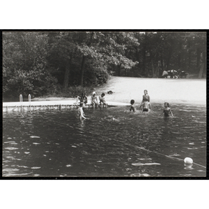 Two swimming supervisors interact with six children