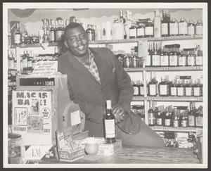 Smiling Man Behind Liquor Store Counter