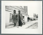 Man and woman walking down sidewalk