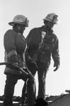 Baldwin Hills fire crew on the roof of a house, Los Angeles, 1985