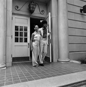 Two individuals exiting a building, 2