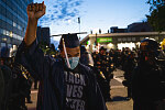 Vallejo resident Louis Michael, 22, raises his fist in solidarity after the death of George Floyd, during a protest in Oakland, Calif., on Friday, May 29, 2020