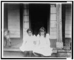 [Two African American girls sitting on a porch]