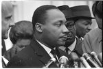 [Martin Luther King, Jr., head-and-shoulders portrait, facing right, at microphones, after? meeting with President Johnson to discuss civil rights, at the White House, 1963]