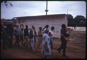 Thumbnail for Guitarists leads a line of residents past a graffiti-covered wall in the Resurrection City encampment