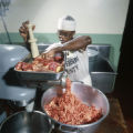 Inmate grinding meet in the kitchen at the Jefferson County jail in either Birmingham or Bessemer, Alabama.