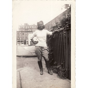 Unidentified girl leans against gate on Haskins Street