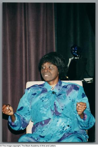 Photograph of Mzuri sitting in a chair on stage