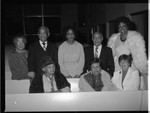 Diane Watson and Gilbert Lindsay posing with others among church pews, Los Angeles, 1983