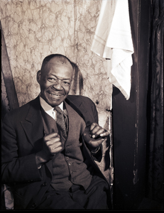 Smiling man wearing a suit and vest, photonegatives.