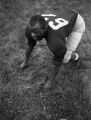 Ted Mack crouches in a four point stance, 1957