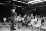 Etheridge Knight: Oxford, Miss. Knight performing at microphone in front of small audience (EKP 2-79-12/11 #295)