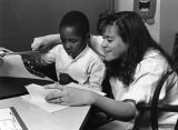 A female student works with a young boy at a typewriter in the Hartman Education Clinic, 1988