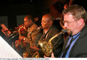 Three saxophonists playing on stage