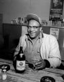 African-American man enjoying a glass of beer at a local bar, Seattle, ca. 1950's