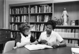 A nursing student receives guidance in conducting research in the library, circa 1985