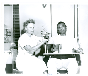 Thumbnail for Photograph of a female physical therapist adjusting the hand splint of an African American patient at the Georgia Warm Springs Foundation, Warm Springs, Meriwether County, Georgia, 1959