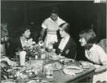 Maid serving students at breakfast