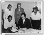 [African American veteran Isaac Woodard, who was beaten and blinded by police, applying for maximum disability benefits, seated with David Edwards; standing (l to r) Oliver W. Harrington, Edward Nottage, and his mother, Mrs. Isaac Woodard]