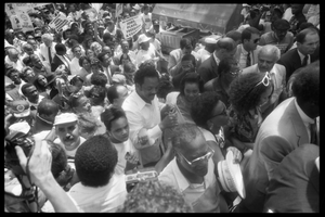 Speakers arriving at the 25th Anniversary of the March on Washington Jesse Jackson, Coretta Scott King (front center), Joseph Lowery (to right of King, partially obscured), Benjamin Hooks (to right of Lowery), and other speakers approach the stage through the crowd