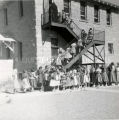 Religious sister leading children into school, 1956