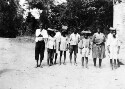 Rural school children of original American stock in Liberia. Each larger child had a smaller one to carry his books which was done in the manner shown. Whether this was just a brother and sister act or an indication of the "domestic" slavery still common thru out Africa we could not determine